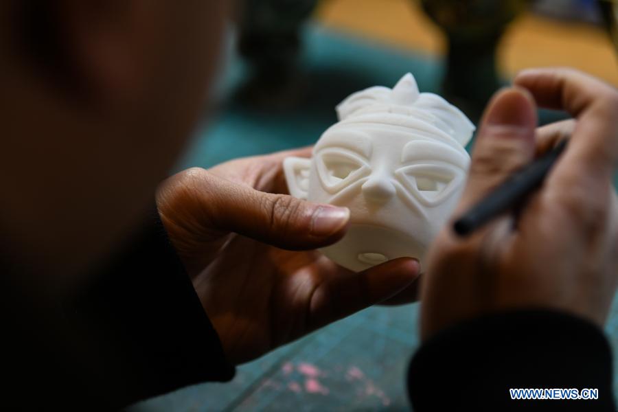 Zeng Zhou makes a toy figure at his workshop in Chengdu, southwest China's Sichuan Province, Feb. 4, 2021. Zeng Zhou is a 31-year-old independent designer working on toy figure design. Inspired by a visiting experience at Sanxingdui Museum in Sichuan, Zeng decided to design model figures imitating bronze relics of the Sanxingdui Ruins, which are believed to be remnants of the Shu Kingdom dating back 2,600 years to 4,800 years, blending traditional Chinese culture with fashion toys. Zeng Zhou is now dedicated to optimizing his design and promoting mass production of his toy figures. 